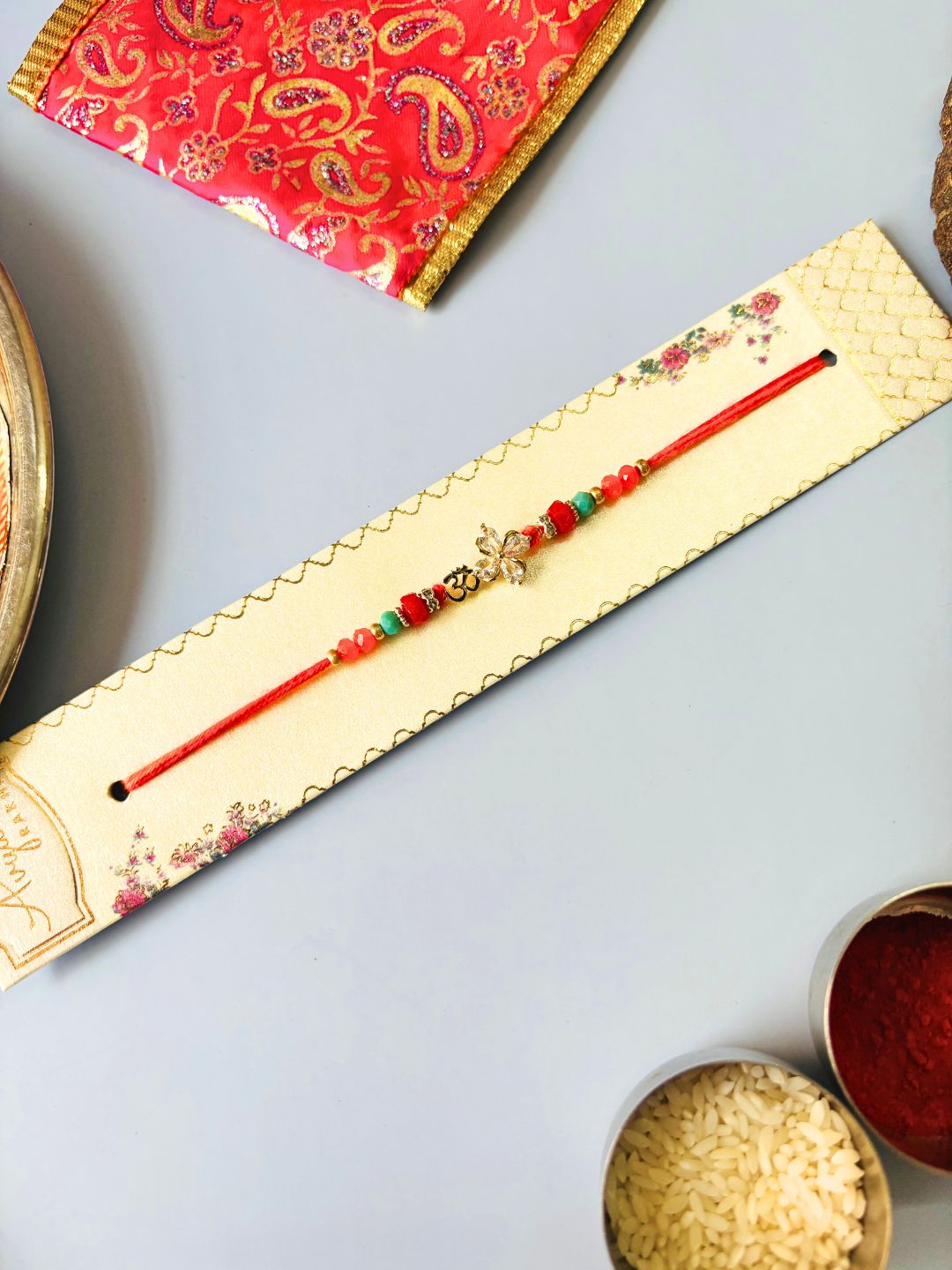 Om AD Stone Rakhi with Floral Accent with Roli Chawal for Brother